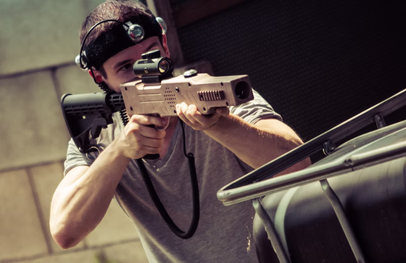 Lasertag-Spieler in Deckung mit Phaser und Sensor-Stirnband